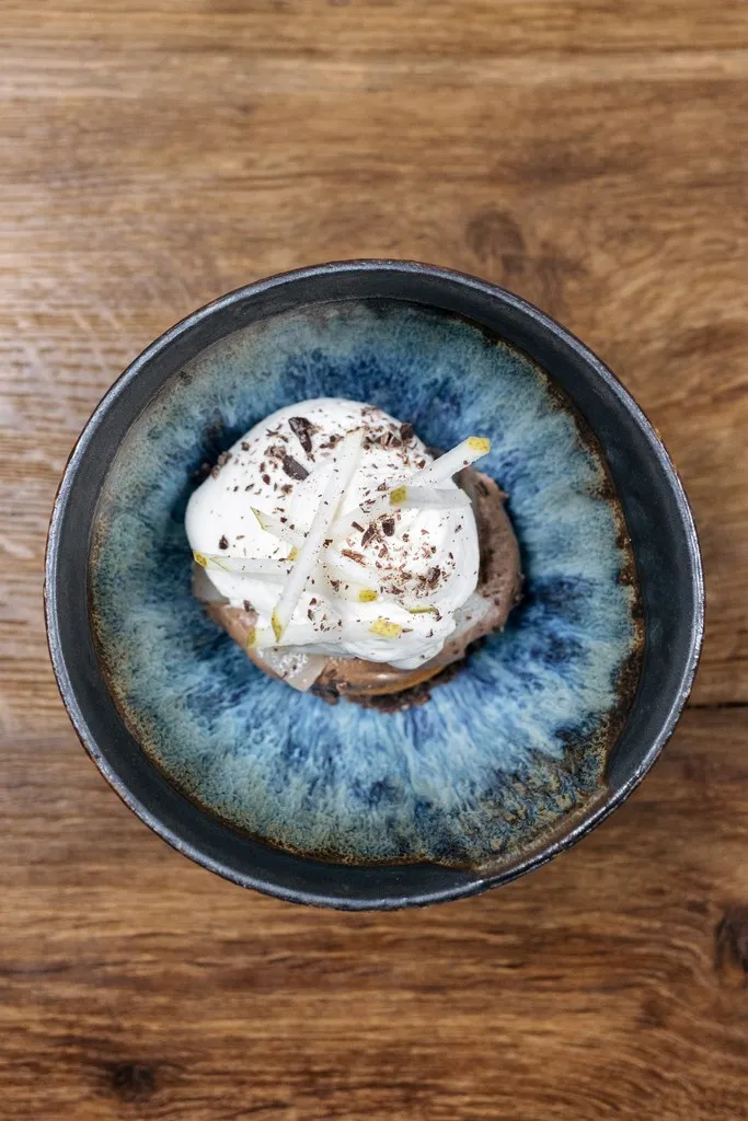 The menu 8 un dessert gastronomique au chocolat dans une tasse de la poterie de la Boissonière servi dans le restaurant le moulin de la santoire à saint-saturnin photographié de haut